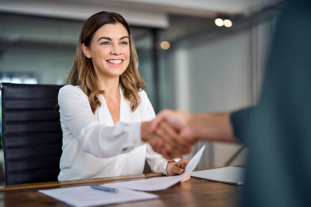 Image of a person shaking hands over a business loan document.